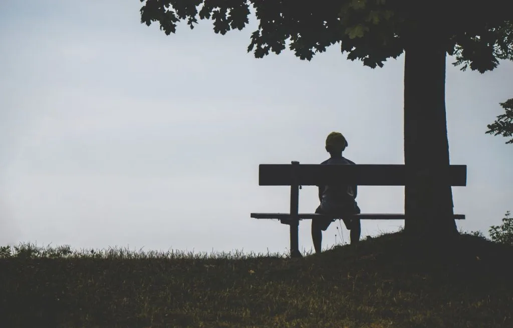 Child sitting alone on bench